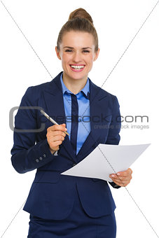 Smiling businesswoman holding paper and pen