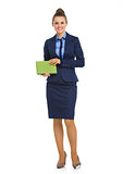 Elegant business woman standing and holding notebook