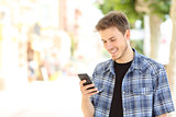 Young casual man using a smart phone in the street