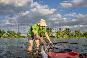 male SUP paddler with paddleboard