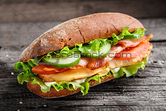 Sandwich with chicken, bacon cheese and vegetables