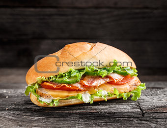 Sandwich with chicken, bacon cheese and vegetables