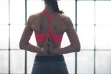 Rear view of woman's hands clasped behind back in yoga pose
