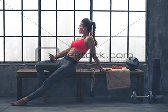 Fit woman in workout gear sitting in profile in loft gym