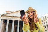 Smiling woman taking selfie at Pantheon doing victory gesture