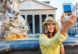 Closeup of mobile phone with smiling woman taking selfie