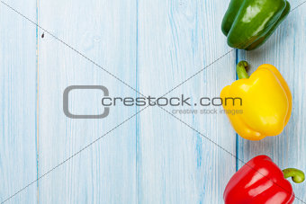 Colorful bell peppers on wooden table