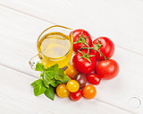Olive oil, tomatoes, basil on wooden table