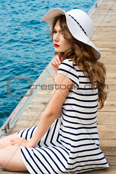 girl sitting on bridge sea in summer day