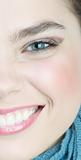 Half face of a women with a blue scarf laughing