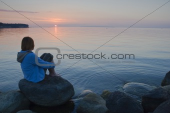 The girl at the sea, looking at a sunset