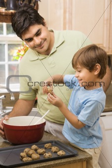 Dad and son making cookies.