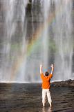 Man and waterfall with rainbow