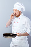 Head-cook holding pan and using phone