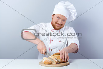 Head-cook slicing freshly baked bread