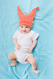 toddler in a striped hat on a blue blanket