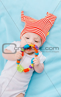 toddler in a striped hat on a blue blanket