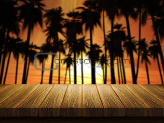 Wooden table with defocussed image of palm trees at sunset