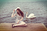 cute girl with hat and near a swan . vintage color
