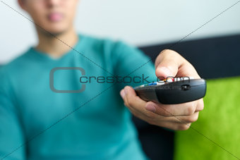 Asian Man Watches TV Changes Channel Holding Remote Control