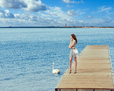 girl on pier with swan