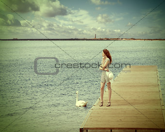 girl on pier with swan. vintage color
