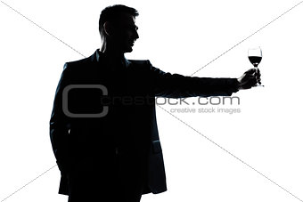 man rising up toasting his glass of red wine silhouette