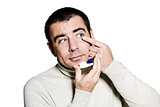 man inserting a contact lens in his eye