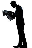 silhouette man walking reading newspaper full length