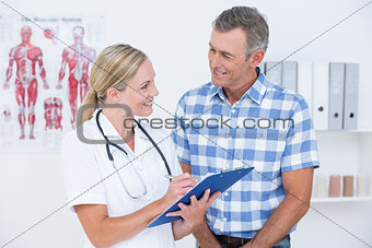 Doctor showing clipboard to her patient