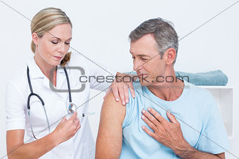 Doctor doing an injection to her patient