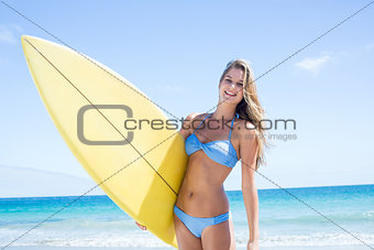 Pretty blonde woman holding surf board