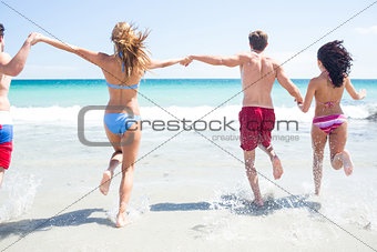 Happy friends running in the water together
