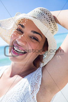 Pretty brunette wearing straw hat and looking at camera