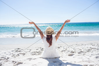 Brunette sitting in the sand and enjoying the air