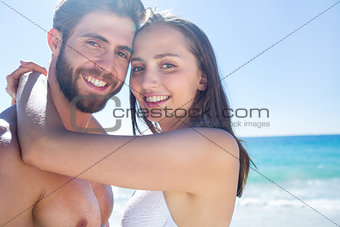 Happy couple hugging and smiling at camera