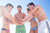 Group of friends standing in circle hands together