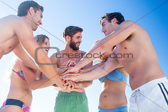 Group of friends standing in circle hands together