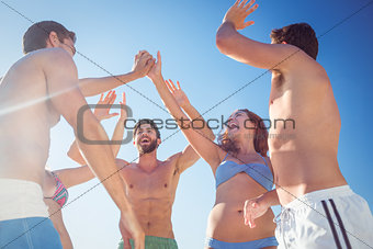 Group of friends standing in circle arms raised