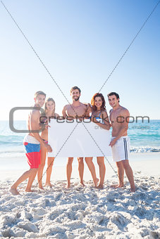 Happy friends holding poster