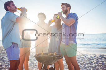 Happy friends doing barbecue and drinking beer