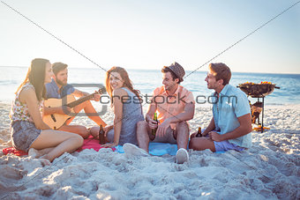 Happy hipsters relaxing and playing guitar