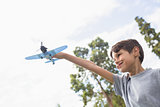 Boy playing with a toy plane at park
