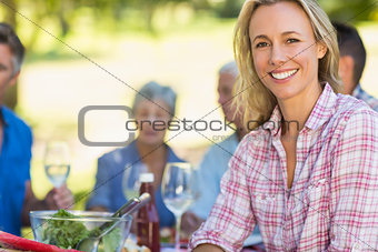 Pretty blonde woman smiling at camera during a picnic