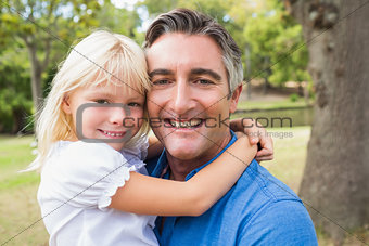 Happy father smiling at camera with his daughter