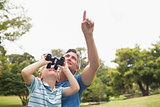 Father and his son using binocular in the park