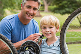 Happy father and his son fixing a bike