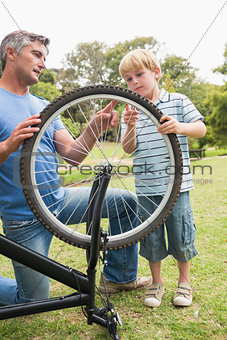 Father and his son fixing a bike