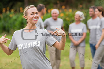 Happy volunteer showing her t-shirt to camera