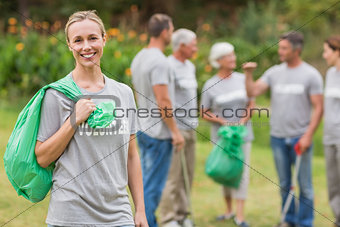 Happy volunteer collecting rubbish